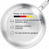 Vista superior interior de una sartén de acero inoxidable Fissler Pure con una infografía descriptiva en alemán.