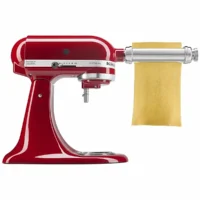 Accesorio laminador de pasta KitchenAid de acero inoxidable estirando una lamina de masa en batidora Artisan.