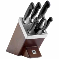 Bloque de cuchillos autoafilable de 7 piezas Zwilling Four Star de madera marrón y acero inoxidable con mangos negros ergonómicos, fotografiado de perfil sobre fondo blanco.