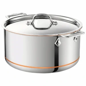 Olla stockpot All-Clad Copper Core de 8 cuartos en acero inoxidable con tapa plana y detalle de franja de cobre visible cerca de la base sobre fondo blanco.