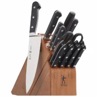 Bloque de madera con el cuchillo de chef Henckels Classic colocado en vertical por fuera, mostrando el logotipo grabado en su hoja de acero inoxidable.