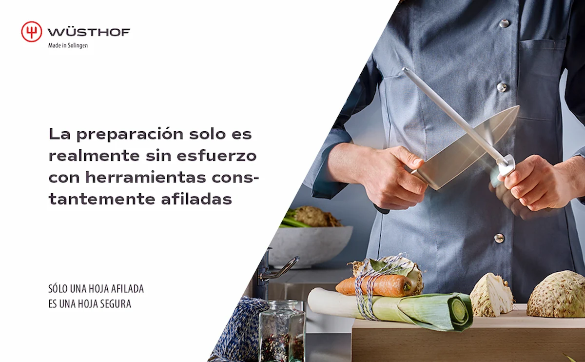 Chef con chaqueta gris afilando un cuchillo con una chaira Wüsthof sobre una tabla con verduras, acompañada del texto promocional en español sobre la preparación sin esfuerzo y hojas seguras.